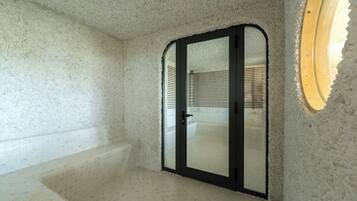 A bathroom with a bathtub, a shower area, and a glass door.