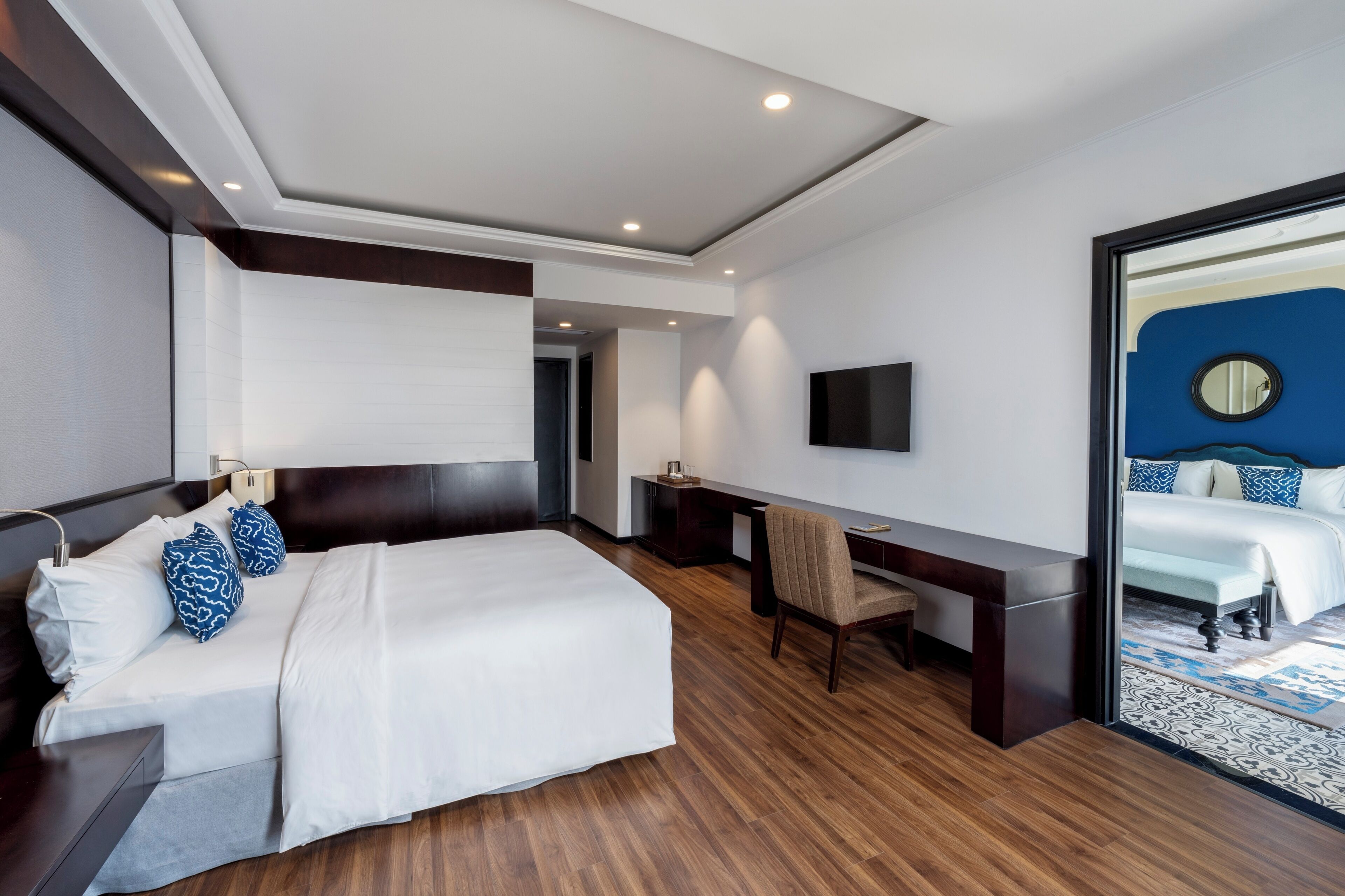 Una habitación de hotel moderna con una cama grande, un escritorio y televisión.
