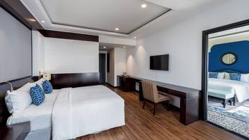 Una habitación de hotel moderna con una cama grande, un escritorio y televisión.