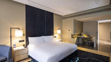 Une chambre d’hôtel avec un grand lit, des tables de chevet, un bureau et une chaise.