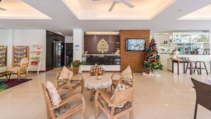 A spacious lobby with a reception desk, a Christmas tree, and a television.