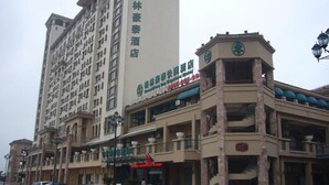 A hotel with a prominent sign in a foreign language, multiple floors, and a parking lot with several cars. - GreenTree Inn Suzhou International Education Zone hotel (Suzhou)