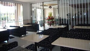 A restaurant with black patterned furniture, glass partitions, and a central flower arrangement. - GreenTree Inn Suzhou International Education Zone hotel (Suzhou)