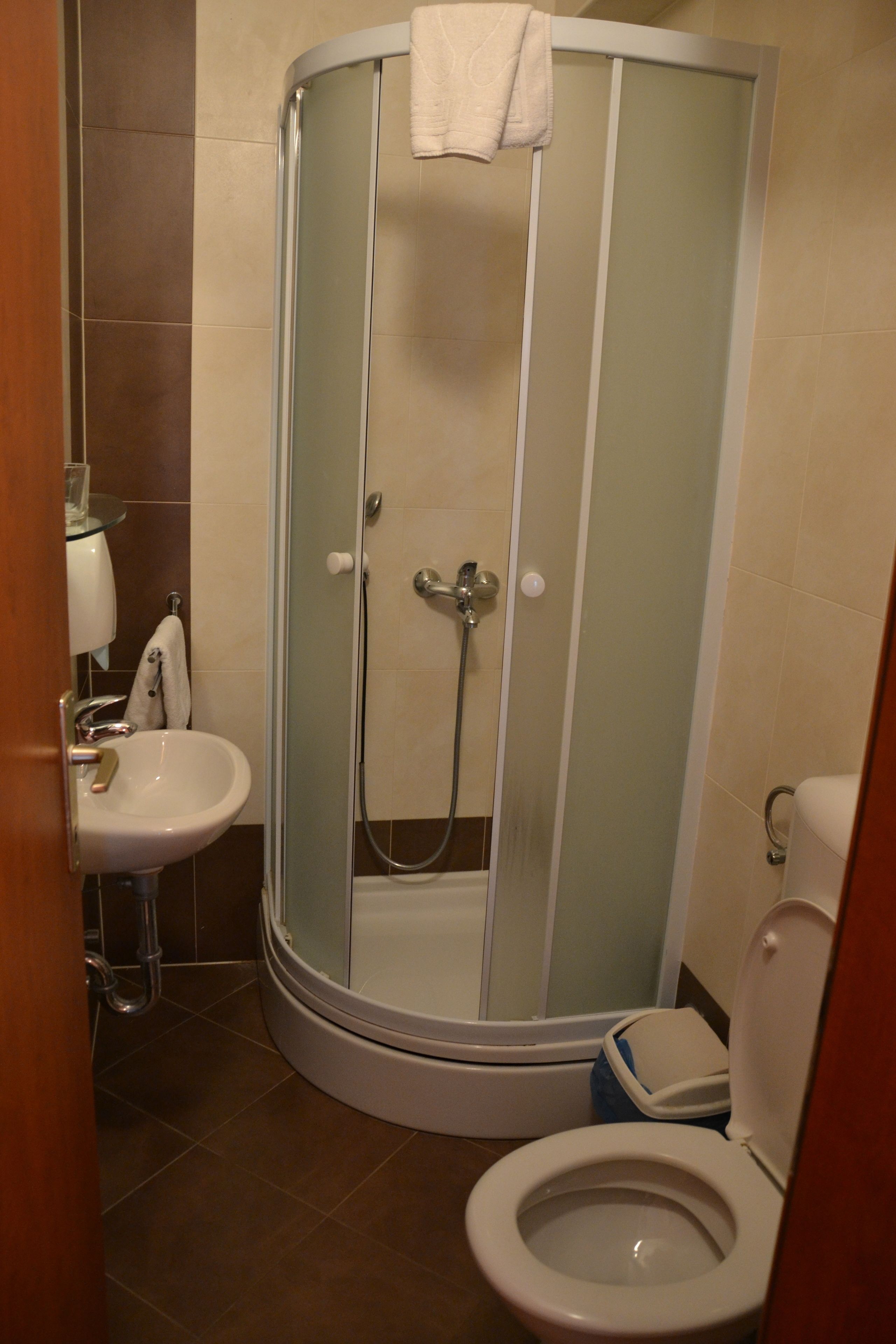 Une salle de bain avec une douche à parois de verre, un lavabo et des toilettes.