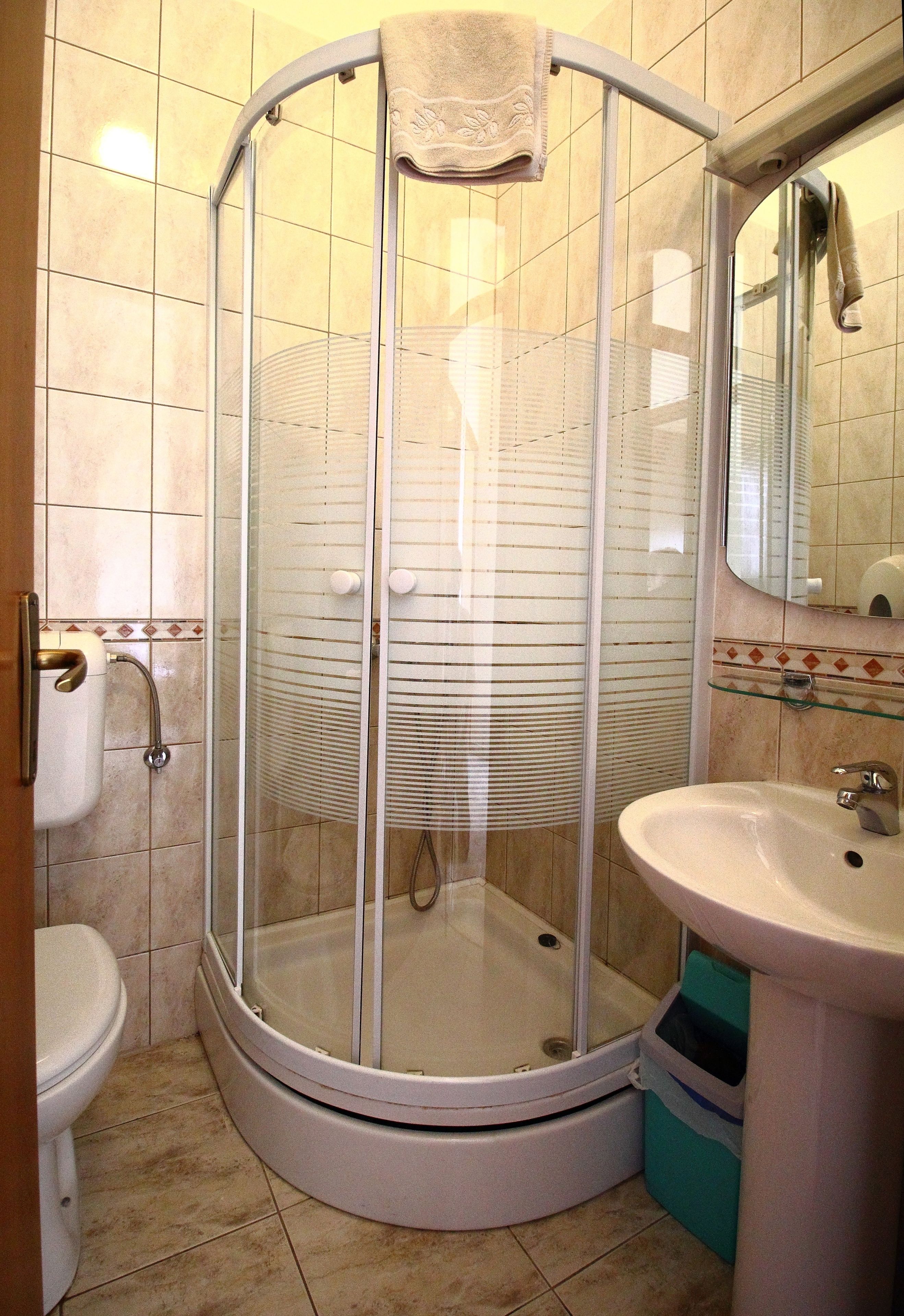 Ein Badezimmer mit Duschkabine, Waschbecken und Toilette.