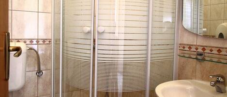 Ein Badezimmer mit Duschkabine, Waschbecken und Toilette.