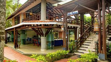 A two-story building with a covered patio area, a staircase, and a sign that reads 'Villa Palomas.'