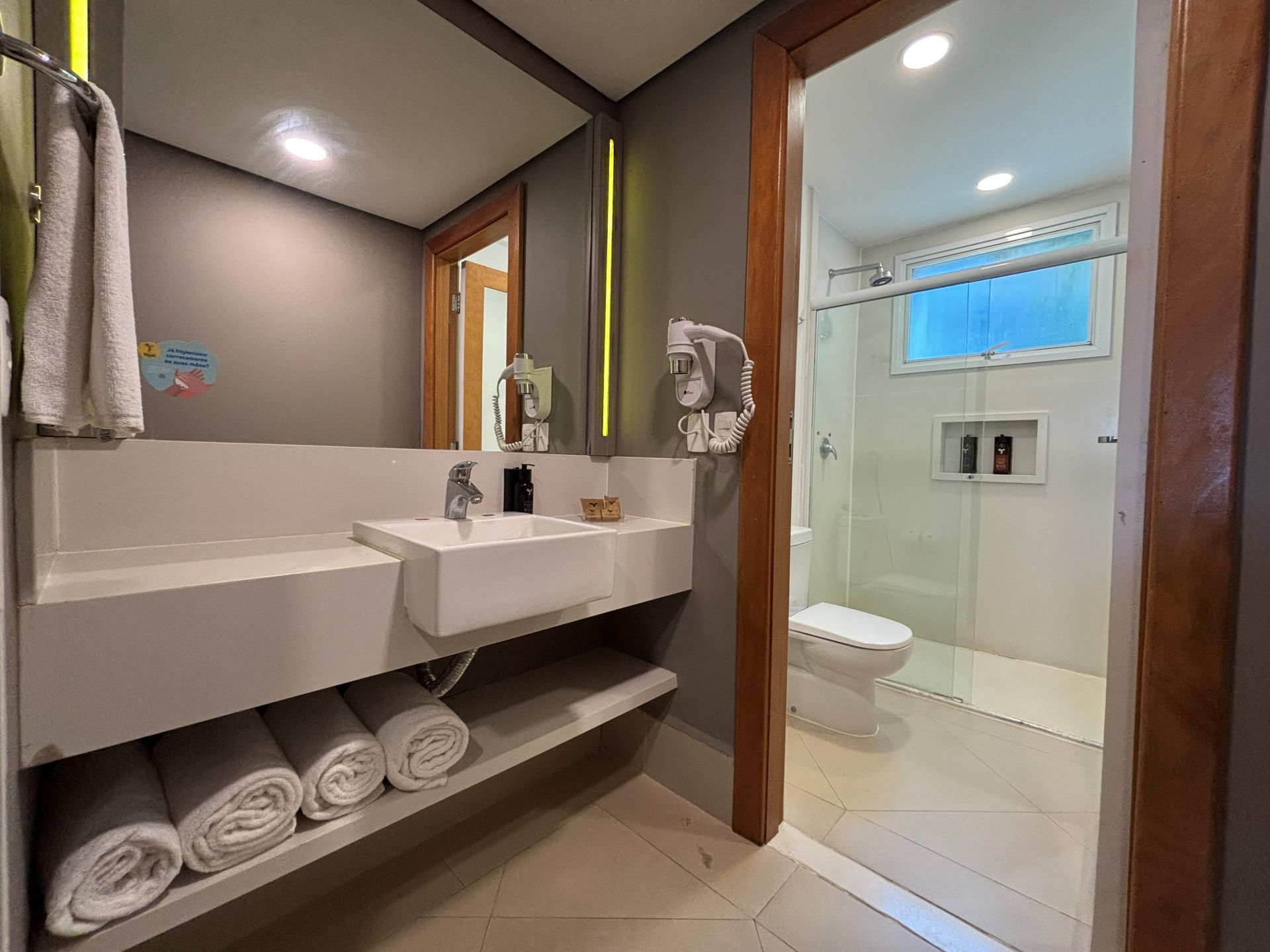Een moderne badkamer met een wastafel, toilet en douche.