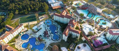 A resort with multiple swimming pools, a large central pool, and a variety of buildings.