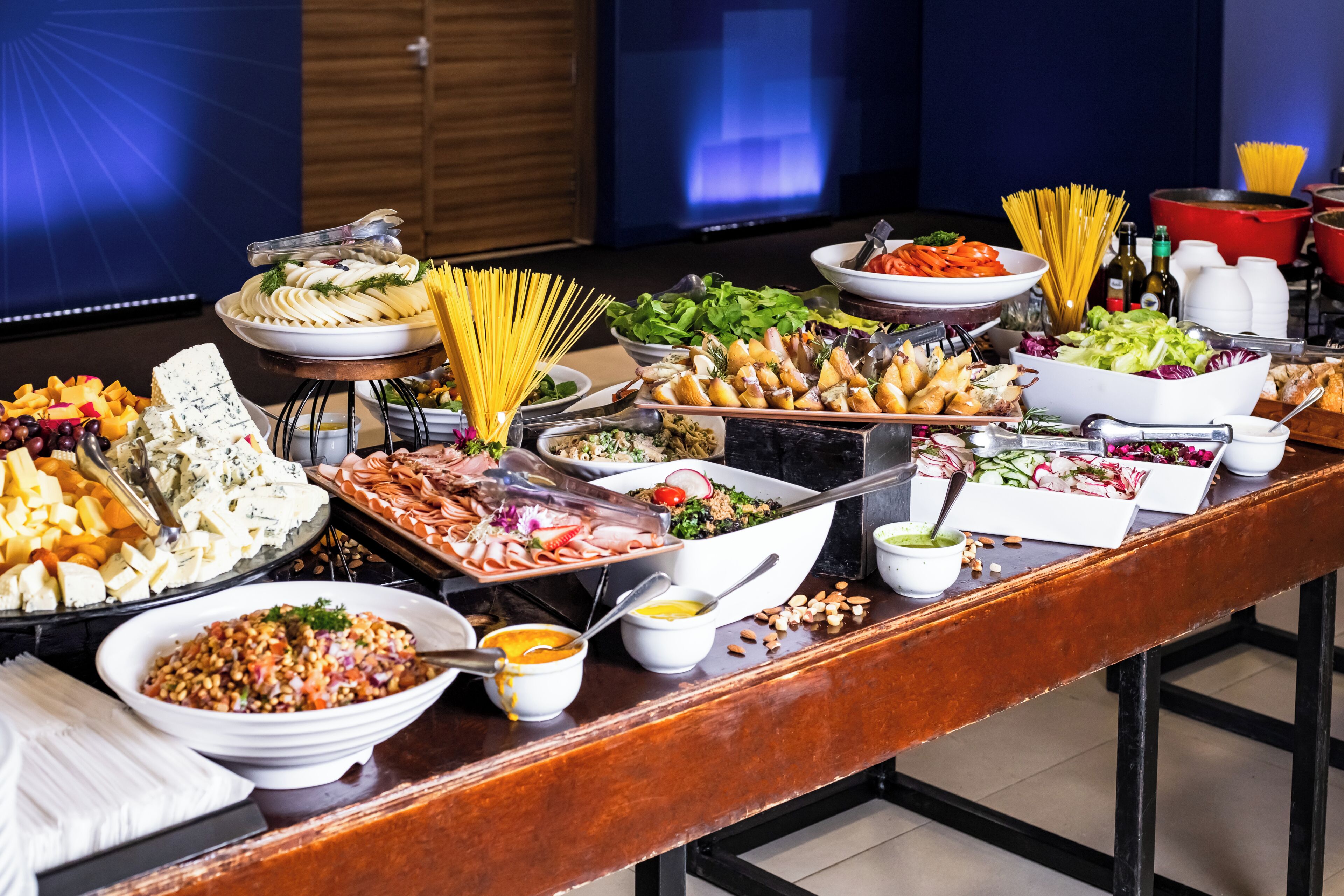 A buffet table with various food items and condiments.