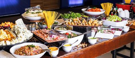 A buffet table with various food items and condiments.