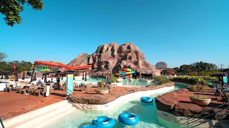 Una piscina techada, una piscina al aire libre, sombrillas