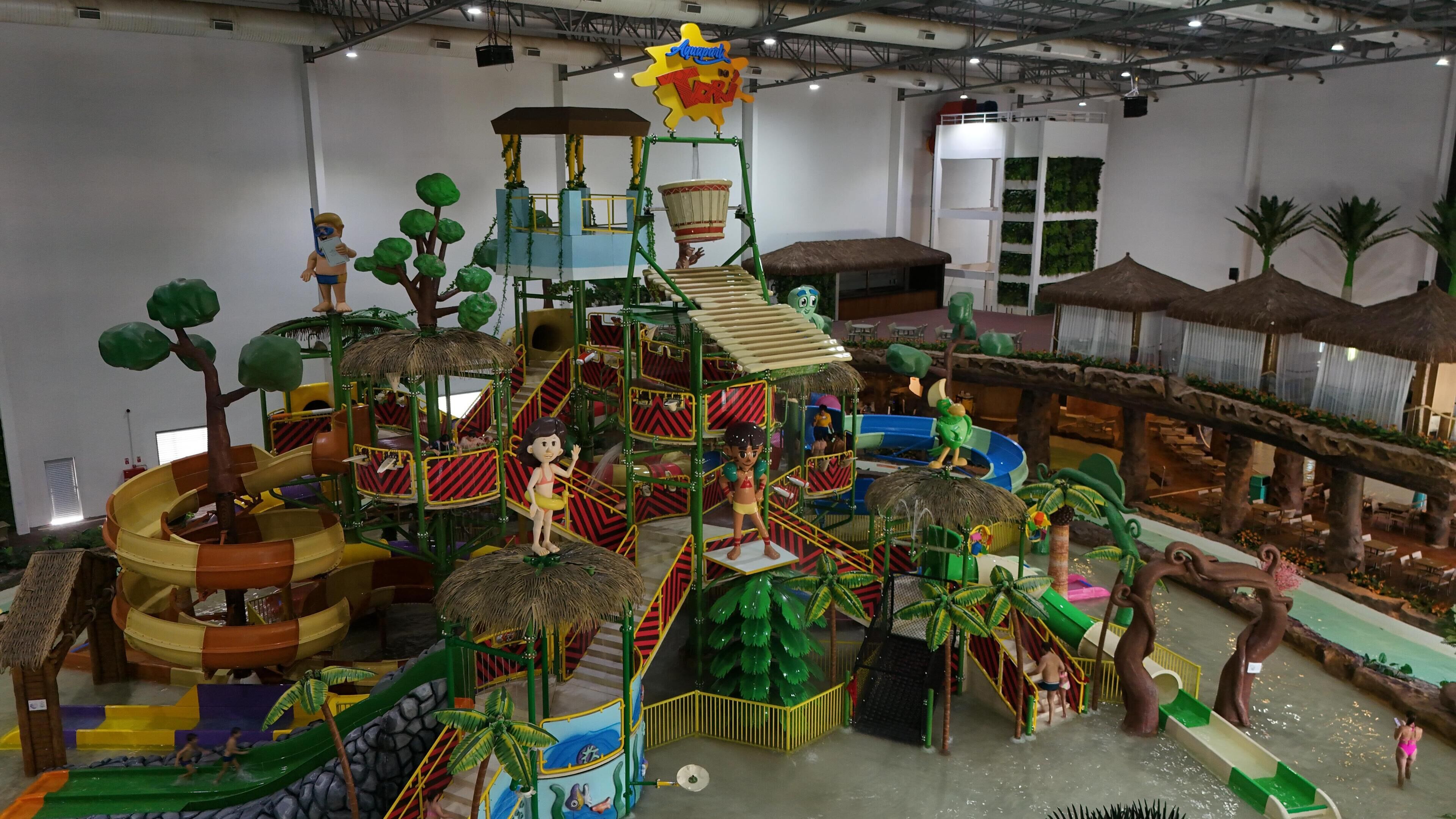 An indoor play area with slides, climbing structures, and themed play zones.