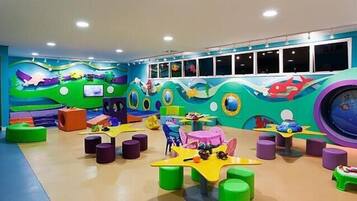 Uma área de recreação infantil com mobiliário colorido e painéis decorativos.