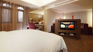 A hotel room with a large bed, a TV, a desk with a chair, and a small table with a vase. - The Metro Hotel (Taipei)