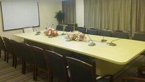 A conference room with a long table, chairs, a projector screen, and a floral arrangement. - Days Hotel Insun Shanghai (Shanghai)