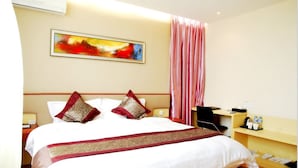 A hotel room with a large bed, a desk with a chair, a small table with a lamp, and a painting on the wall. - Days Hotel Insun Shanghai (Shanghai)