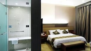 A hotel room with a large bed, bedside tables, a nightstand, a bench, a glass-enclosed shower, and a plain wall. - Days Hotel Insun Shanghai (Shanghai)