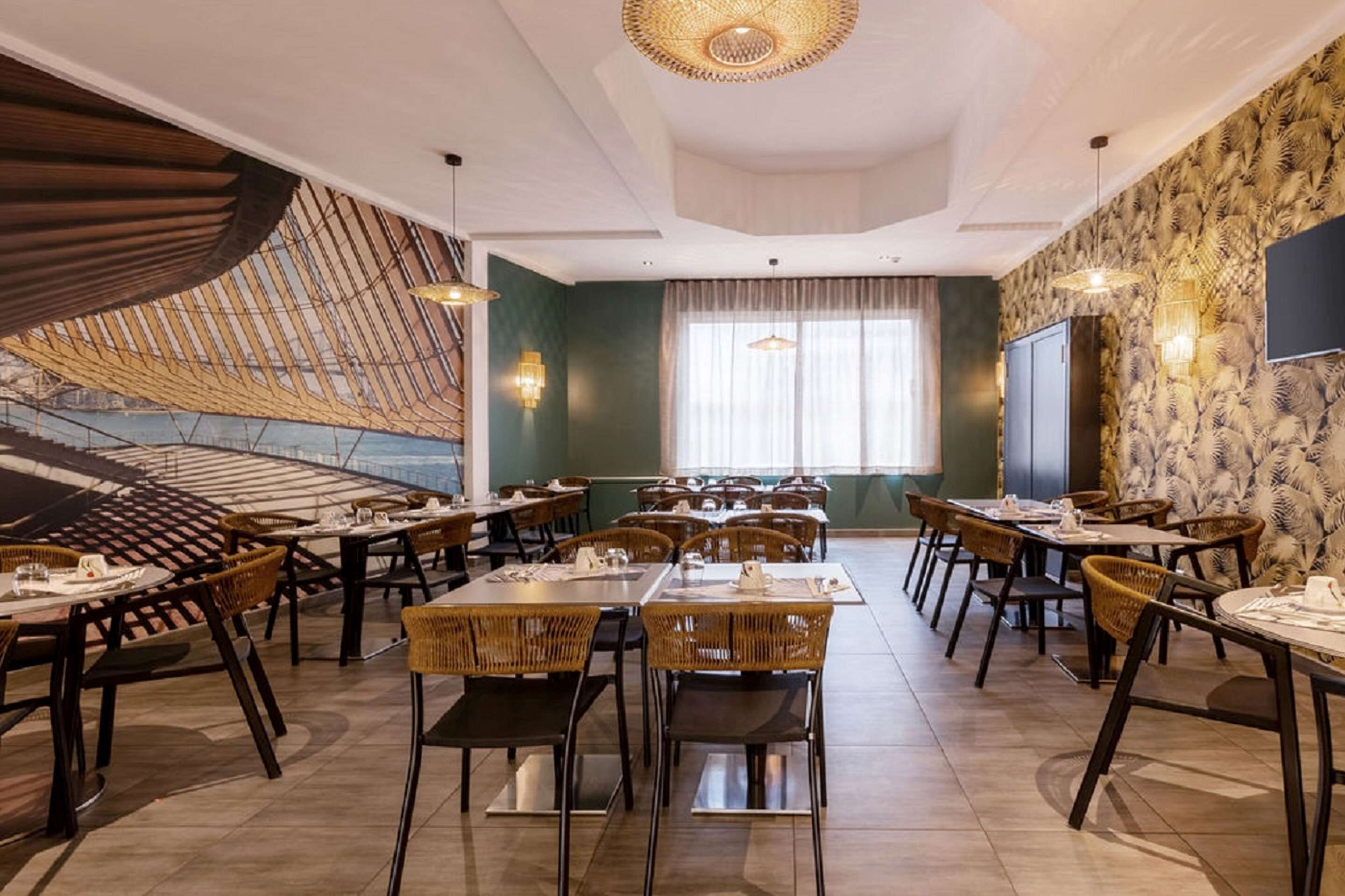 Un restaurante con varias mesas y sillas, un amplio ventanal con cortinas y un muro con diseño.