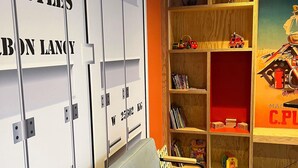 A room with a grey sofa, a wooden bookshelf with toys and books, and white lockers with weight labels. - ibis Styles Bourbon Lancy (Bourbon-Lancy)