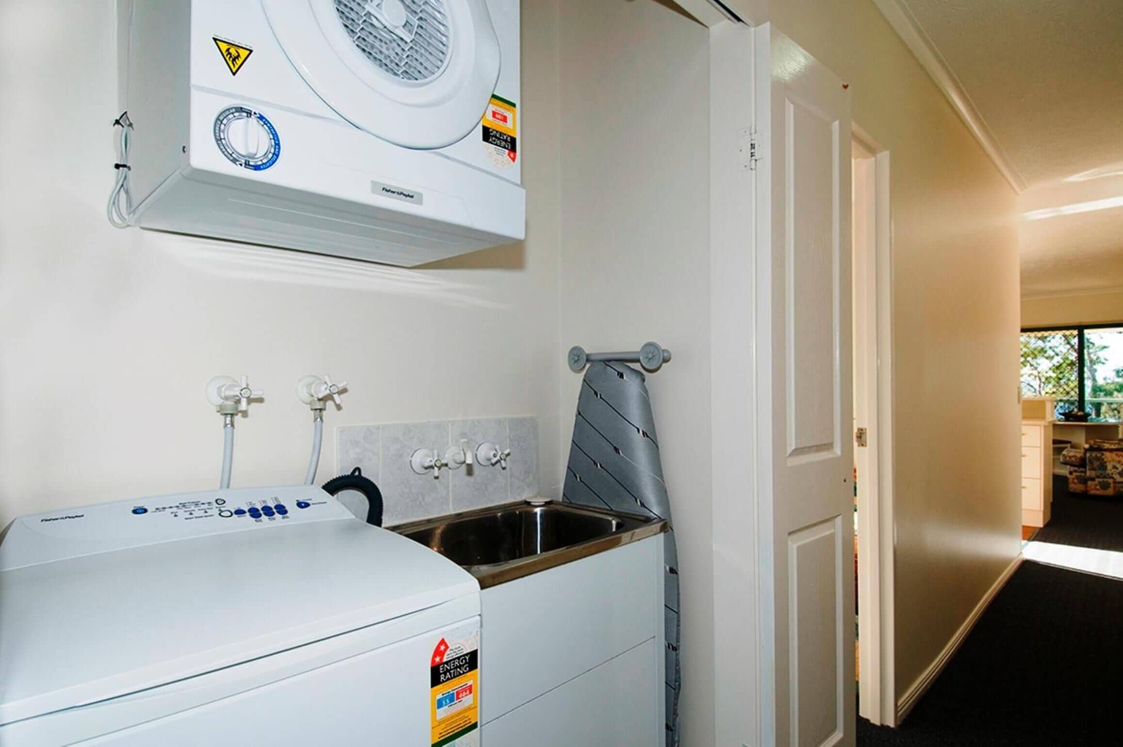 A laundry area with a washing machine, a dryer, and a sink.