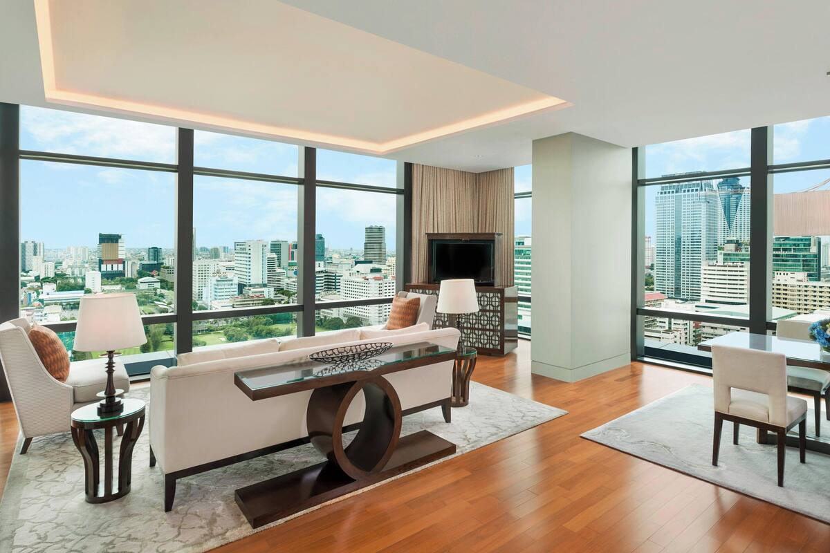 A modern living room with a large window, a sofa, a coffee table, and a TV.
