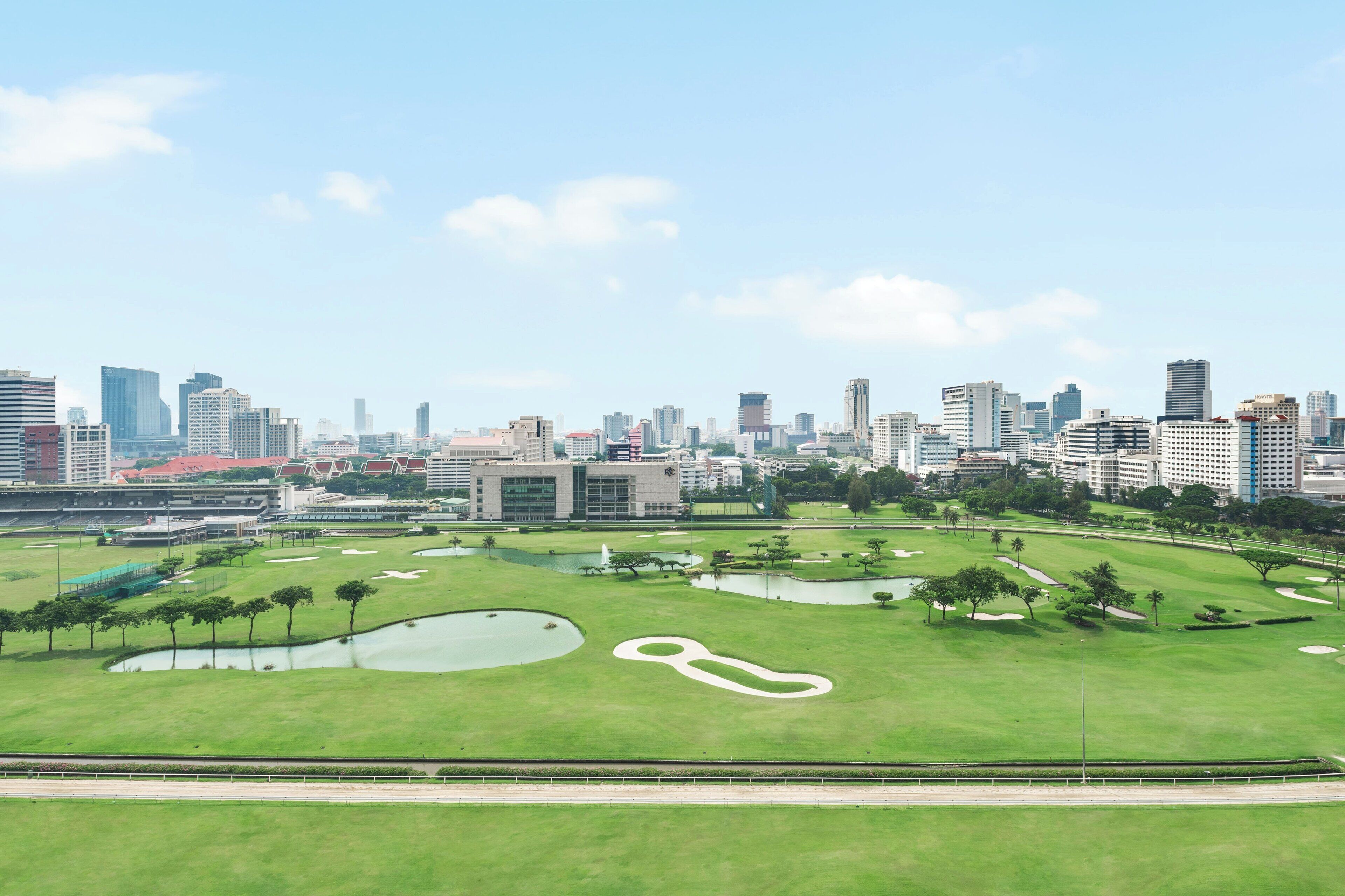 A golf course with a city skyline in the background.