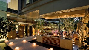 A modern indoor garden with seating areas, water features, and ambient lighting. - The St. Regis Bangkok (Bangkok)