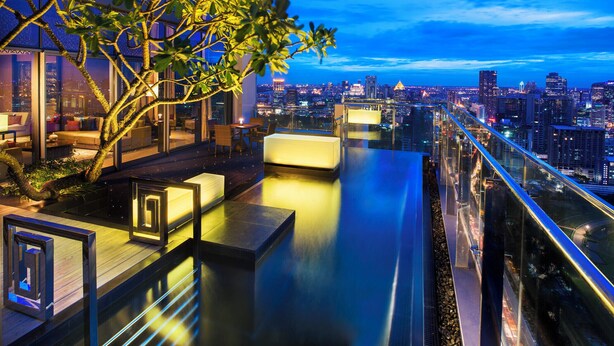 A rooftop terrace with a city view, seating areas, and a glass railing. - The St. Regis Bangkok (Bangkok)