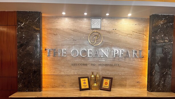 A reception desk with a marble top and a sign that reads "The Ocean Pearl." - The Ocean Pearl (Mangaluru)