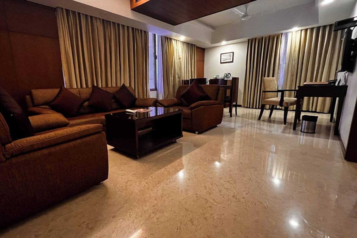 A modern living room with a sectional sofa, a coffee table, and a dining area with a chair and table.