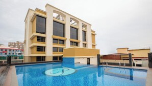 A modern building with a large pool area. - The Ocean Pearl (Mangaluru)