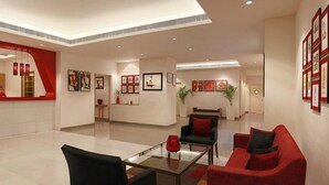 A modern hotel lobby with a reception desk, seating area, and artwork on the walls. - Red Fox by Lemon Tree Hotels, Hyderabad (Hyderabad)