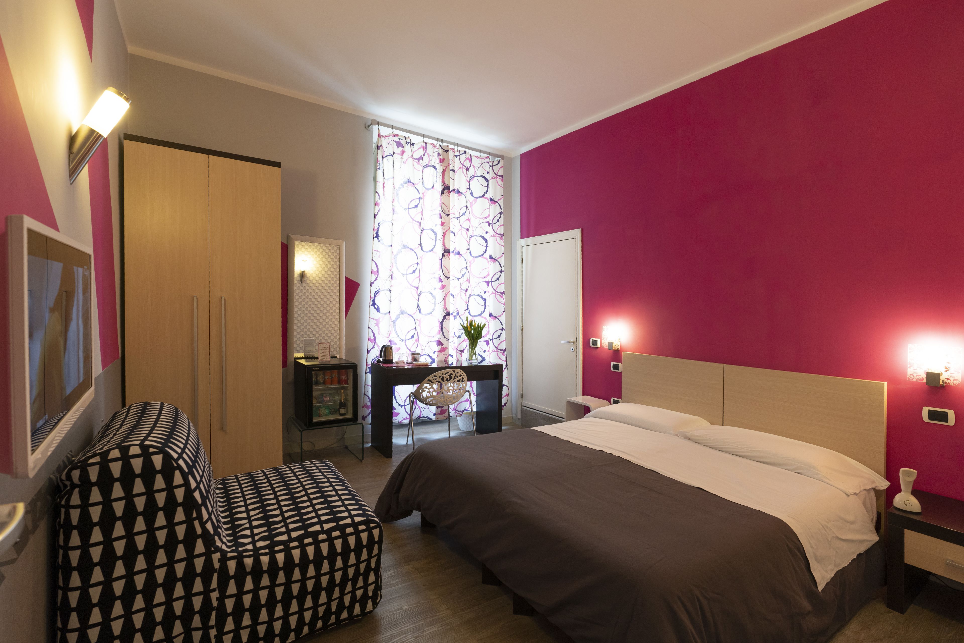 A bedroom with a bed, a desk, and a chair.