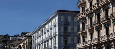 A multi-story building with classical architecture, featuring balconies and large windows.