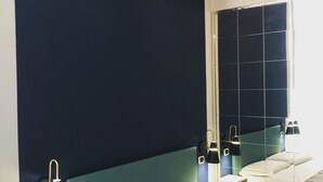 A hotel room with a large bed, two bedside tables, a nightstand, a mirror, and a window. - H Rooms Boutique Hotel (Naples)