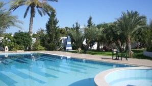 A swimming pool with palm trees and a clear blue sky. - Menzel Dija (Djerba Midun)
