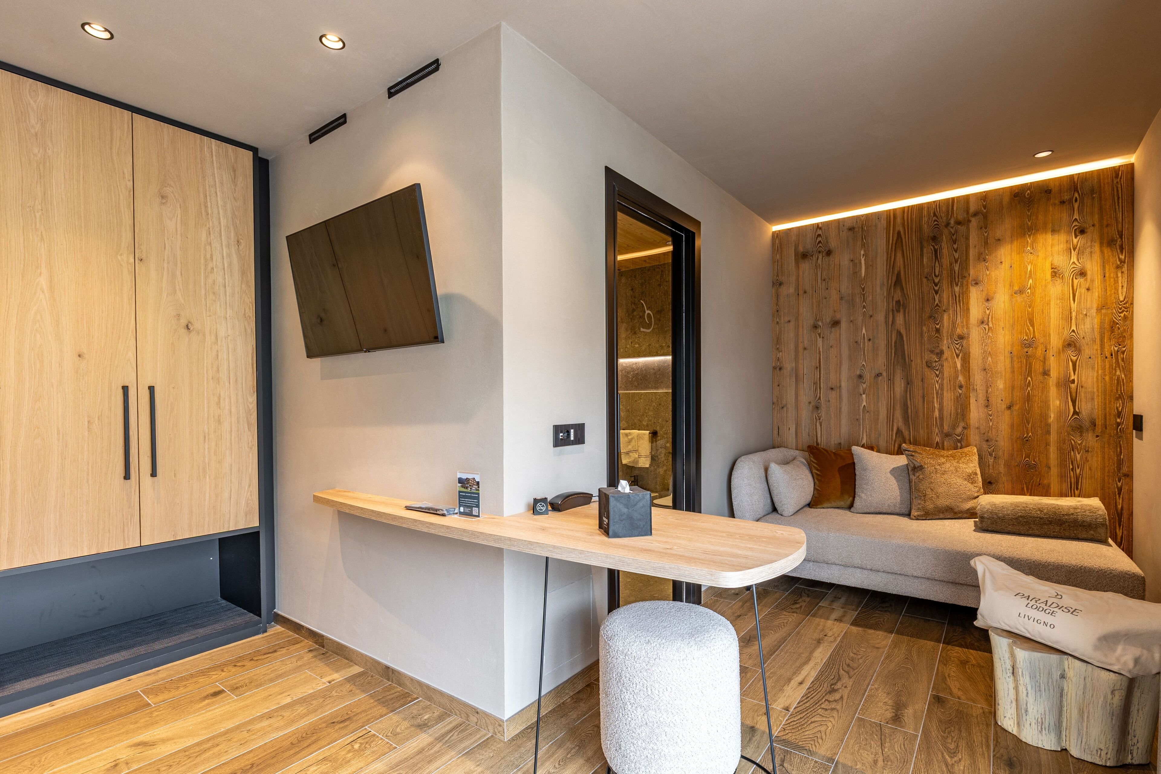 Ein modernes Wohnzimmer mit einer Holzwand, einem Sofa und einem kleinen Tisch mit Taschentuchbox.