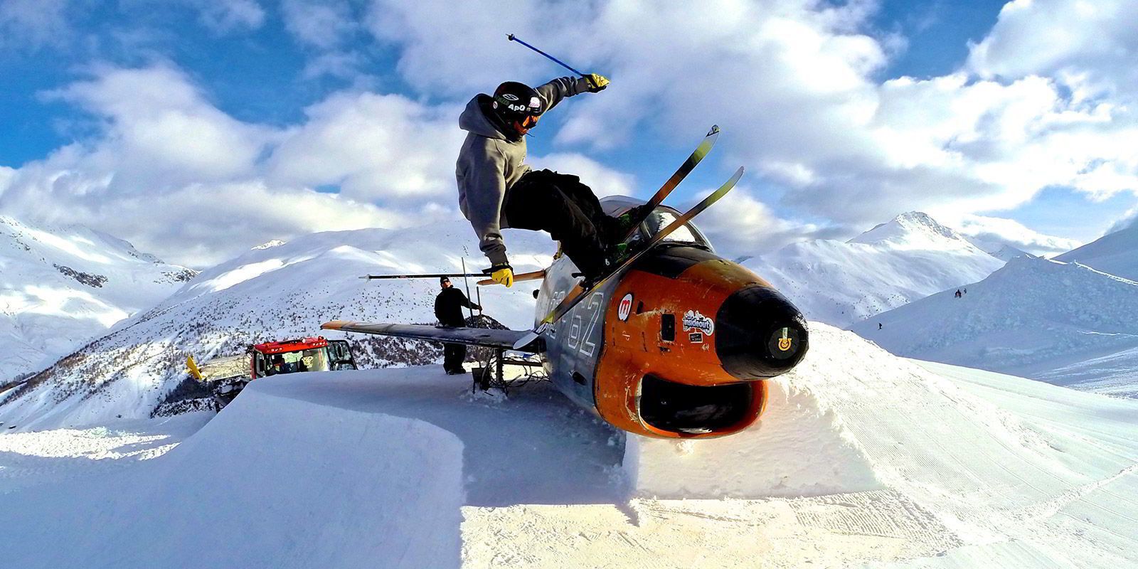 A person performing a ski jump on a snowy mountain slope.