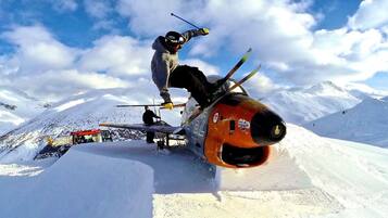 A person performing a ski jump on a snowy mountain slope.