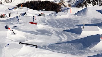 Une piste de ski enneigée, avec différents tremplins et parcours de ski.