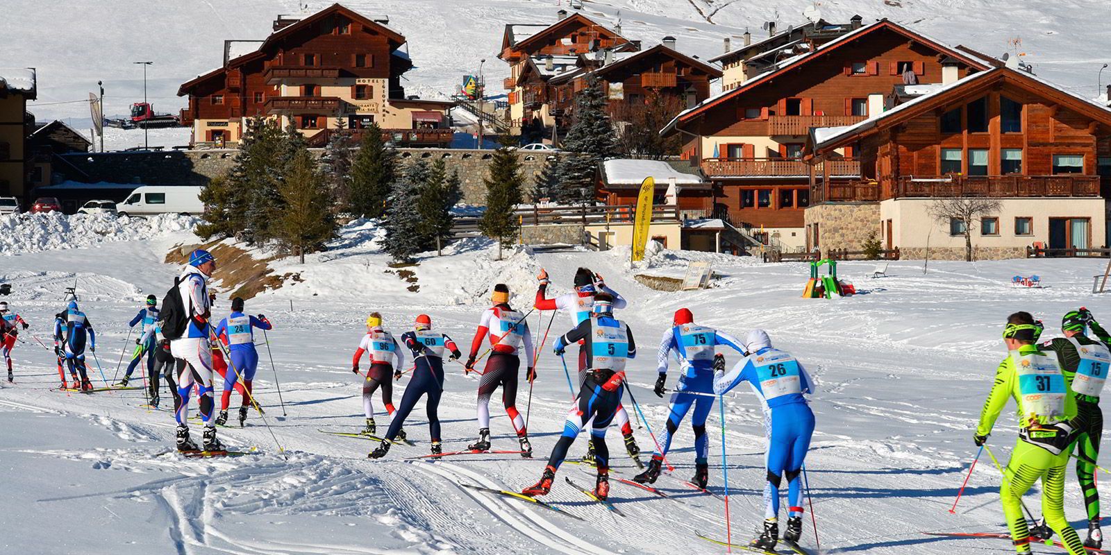 Une compétition de ski de fond où les participants portent des tenues de différentes couleurs.