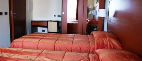 Una habitación de hotel con una cama grande, un escritorio, una silla y un armario.