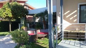A patio area with outdoor seating, a potted plant, and a metal gate. - Hotel Gullo (Curinga)