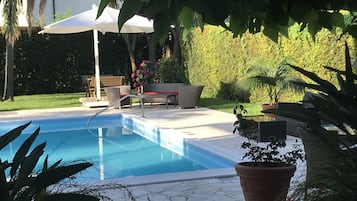 Piscine extérieure, parasols de plage, chaises longues