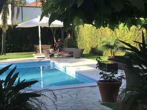 Piscine extérieure, parasols de plage, chaises longues