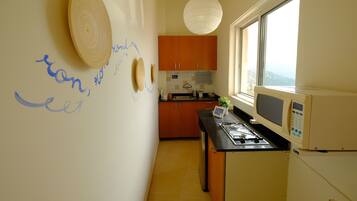 A kitchen with wooden cabinets, a microwave, and a window with a view.