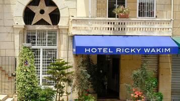 Un edificio con una tenda blu che riporta la scritta "HOTEL RICKY WAKIM".