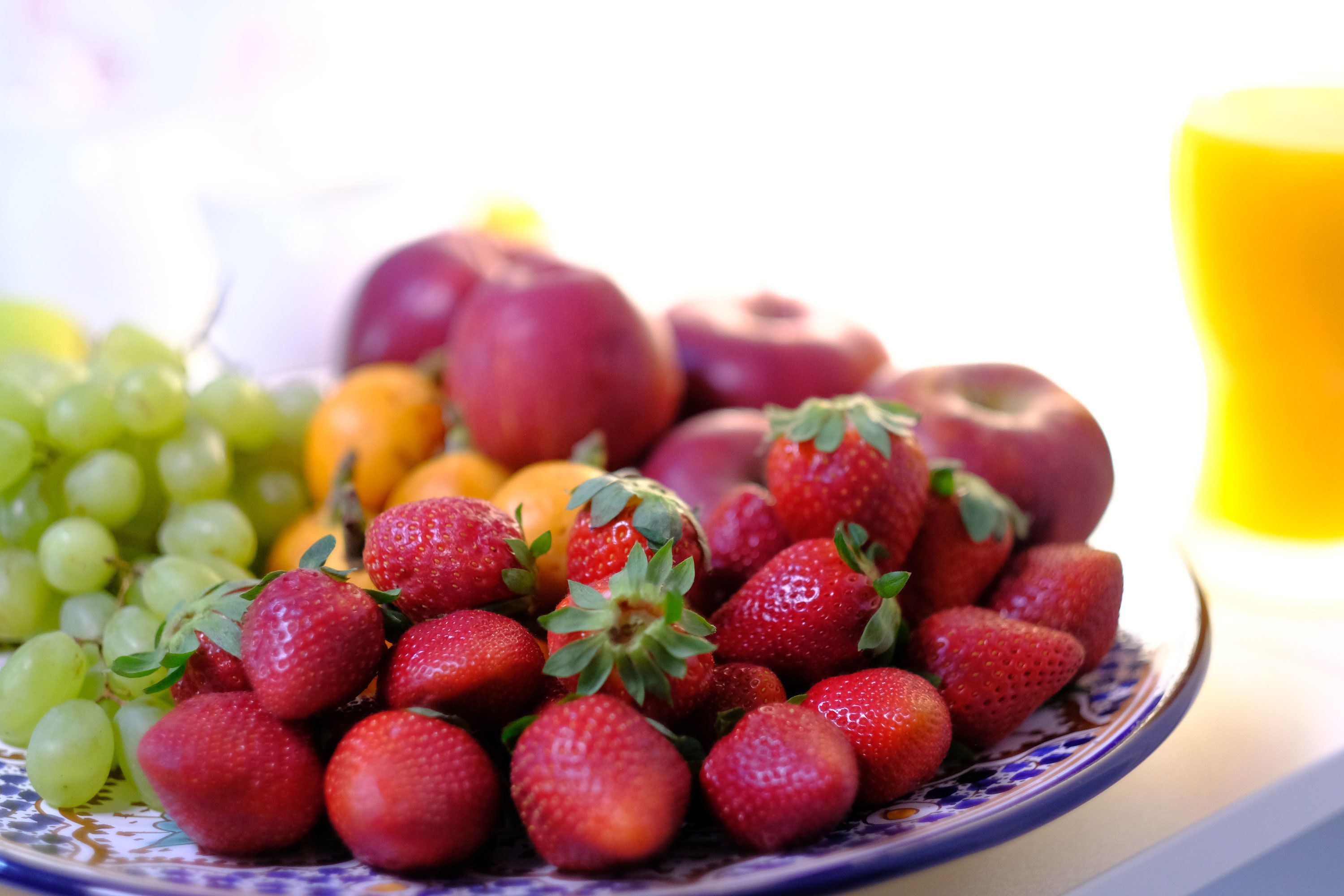 A plate of strawberries and grapes.