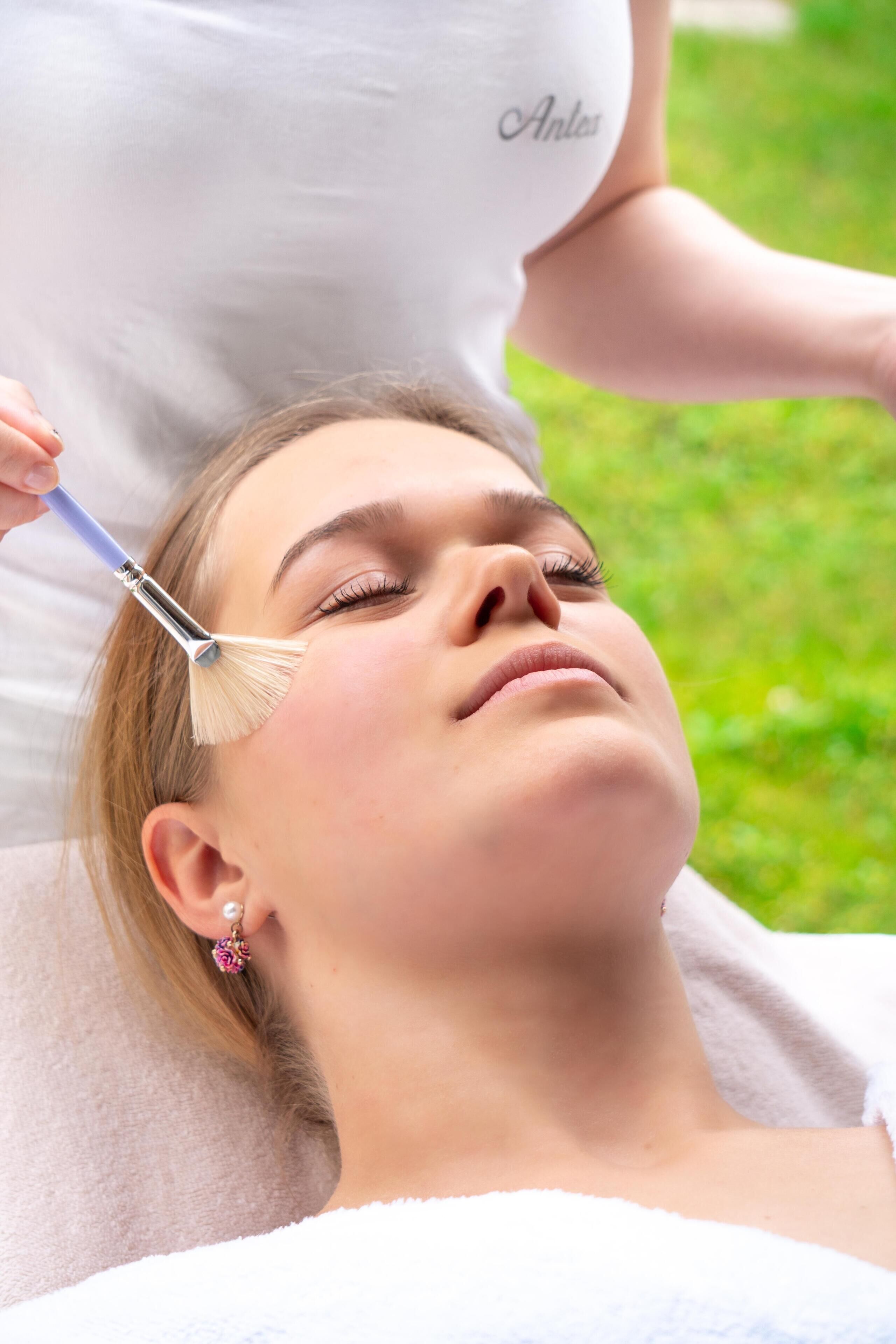 Una persona recibiendo un tratamiento facial al aire libre.